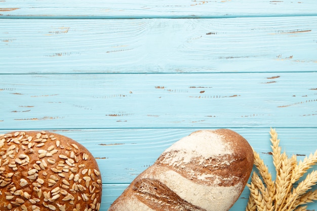 Frisch gebackenes dunkles Brot auf blauem Holztisch