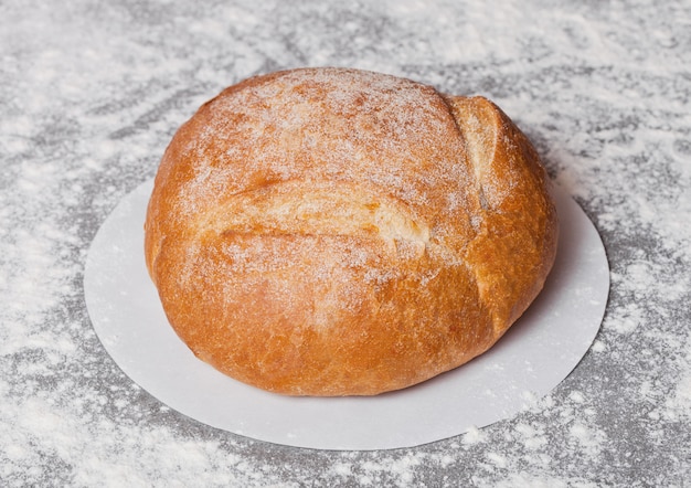 Frisch gebackenes freies organisches Brot des Glutens mit Mehl auf grauem Hintergrund