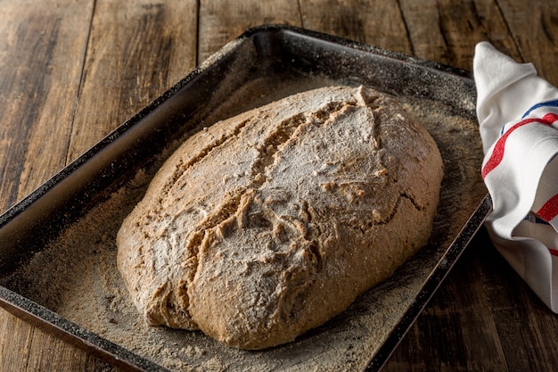 Frisch gebackenes hausgemachtes Brot auf hölzernem Hintergrund