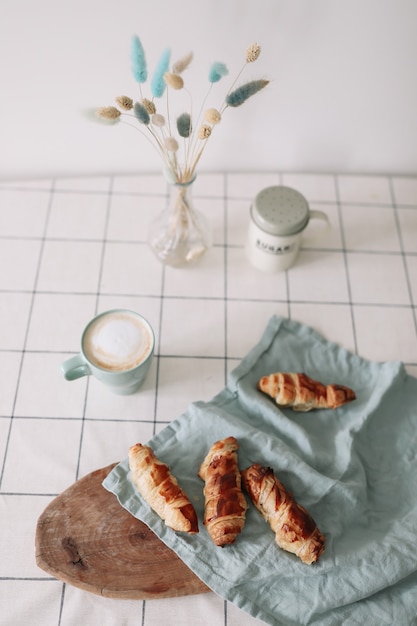 Frisch gebackenes hausgemachtes Gebäck am Küchentisch Frühstück mit Kaffee und Brötchen