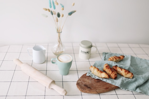 Frisch gebackenes hausgemachtes Gebäck am Küchentisch Frühstück mit Kaffee und Brötchen