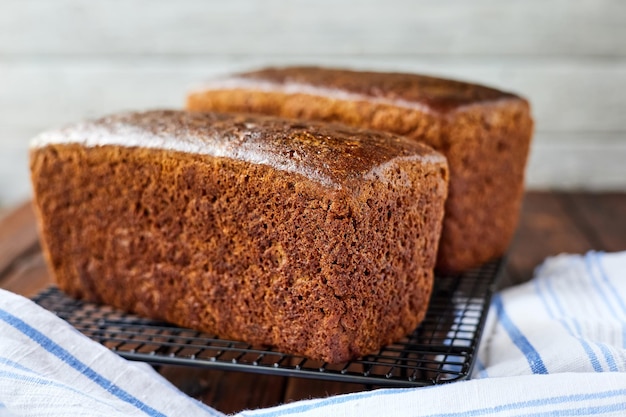 Frisch gebackenes hausgemachtes Roggenbrot auf Textil- und Holzhintergrund