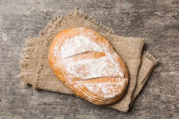 Frisch gebackenes köstliches französisches Brot mit Serviette auf rustikaler Tischplatte Ansicht Gesundes Weißbrot