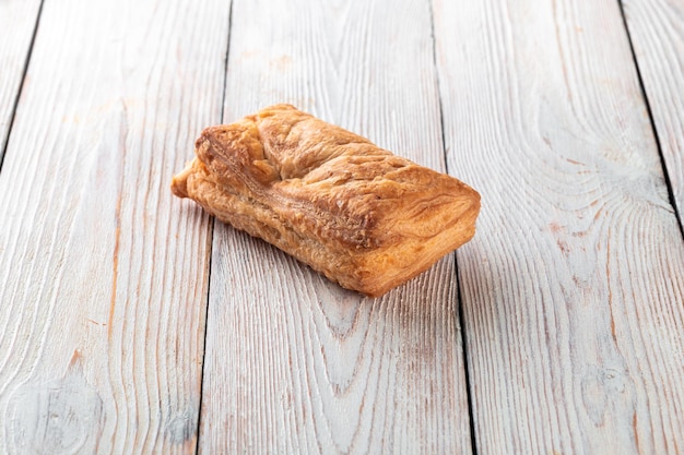 Frisch gebackenes leckeres Brötchen auf einem weißen Holztisch Leckere Backwaren direkt vom Bäcker