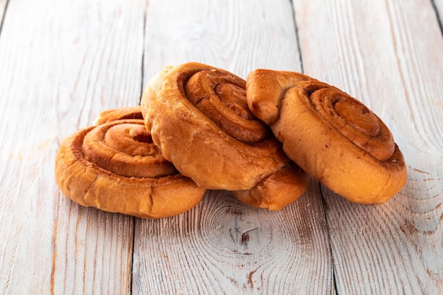 Frisch gebackenes leckeres Brötchen auf einem weißen Holztisch Leckere Backwaren direkt vom Bäcker