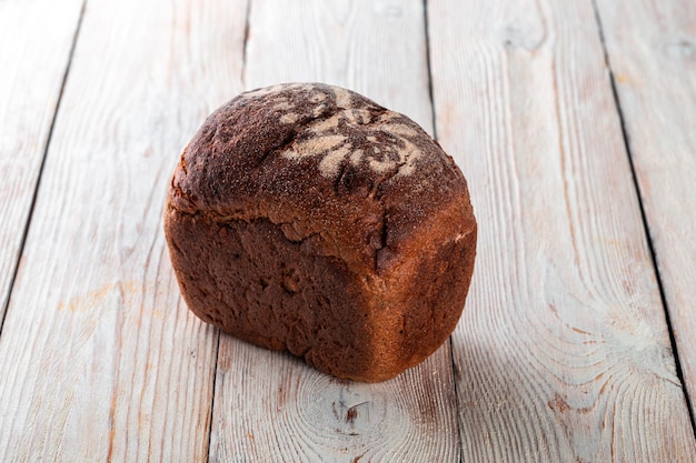 Frisch gebackenes leckeres Brot auf einem weißen Holztisch Leckere Backwaren direkt vom Bäcker Weiß