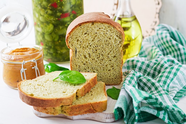 Frisch gebackenes Spinatsbrot auf einem weißen Holztisch. Rustikaler Stil. Bäckerei Essen.