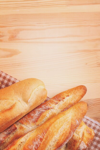 Frisch gebackenes Stangenbrot und Brot auf hölzernem Hintergrund