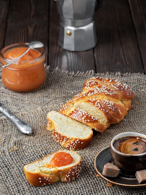 Frisch gebackenes süßes geflochtenes Brot, Kaffee und Marmelade