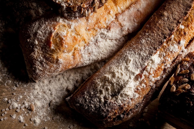 Frisch gebackenes traditionelles Brot mit Mehl auf Holztisch Frisches Baguette mit Mehl