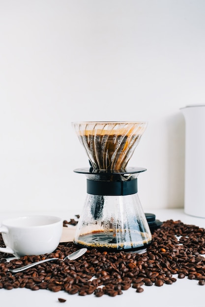 Foto frisch gebrühter kaffee in einer tasse mit alternativer methode, mit gießen über tropfer und papierfilter.