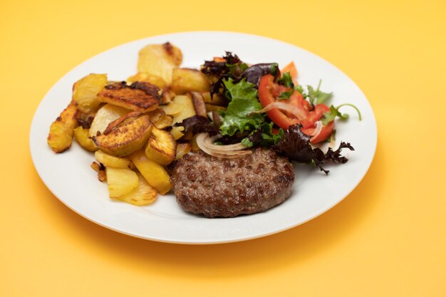 Frisch gegrillte Hamburger mit Kartoffeln und Salat auf dem Teller