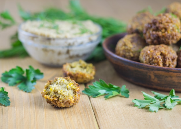 Frisch gekochte Falafel auf Salatblättern auf einem Tisch mit Tahinisauce