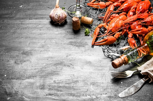 Frisch gekochte Langusten mit Knoblauch und Weißwein. Auf einer schwarzen Tafel.