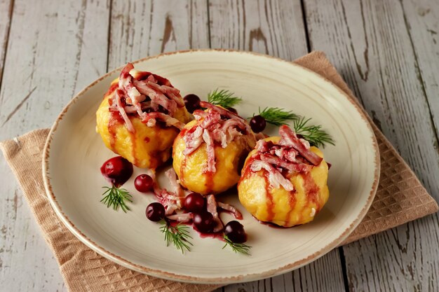 Frisch gekochte schwedische Kartoffelknödel mit Preiselbeersauce auf hellem Hintergrund.