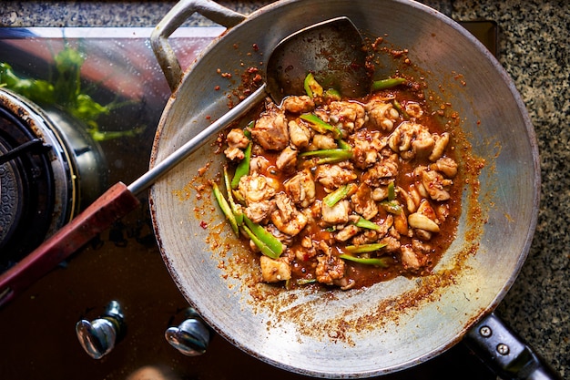 Foto frisch gekochtes rotes thailändisches curry im wok mit huhn