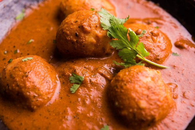 Frisch gekochtes würziges Kartoffelcurry in Bratpfanne oder scharfer Dum Aloo serviert mit Tandoori Roti oder Naan oder indischem Brot oder Chapati und grünem Salat, selektiver Fokus