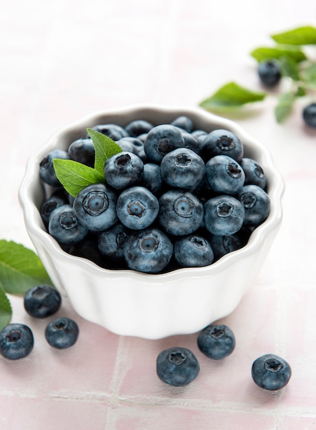 Frisch gepflückte Blaubeeren auf einem rosafarbenen Fliesenhintergrund. Konzept für gesunde Ernährung