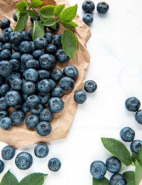 Frisch gepflückte Blaubeeren auf weißem Fliesenhintergrund. Konzept für gesunde Ernährung