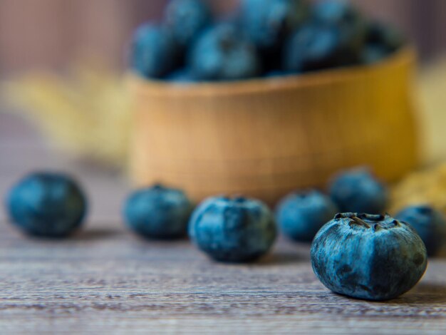 Frisch gepflückte Blaubeeren in einer Holzschale auf einem hölzernen Hintergrund. Gesundes Essen und Ernährung. Platz für Text.