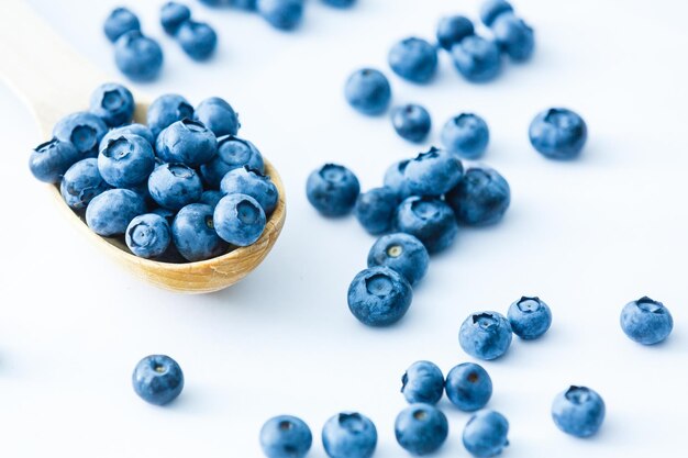 Frisch gepflückte Heidelbeeren in Holzschale. frische Heidelbeeren auf einem weißen rustikalen Tisch. selektiver Fokus.