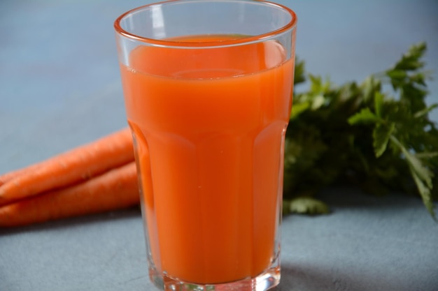 Frisch gepresster Karottensaft in einem Glas mit Karotten auf einem Tisch Gesunde Ernährung Detox Diät und vegetarisches Konzept