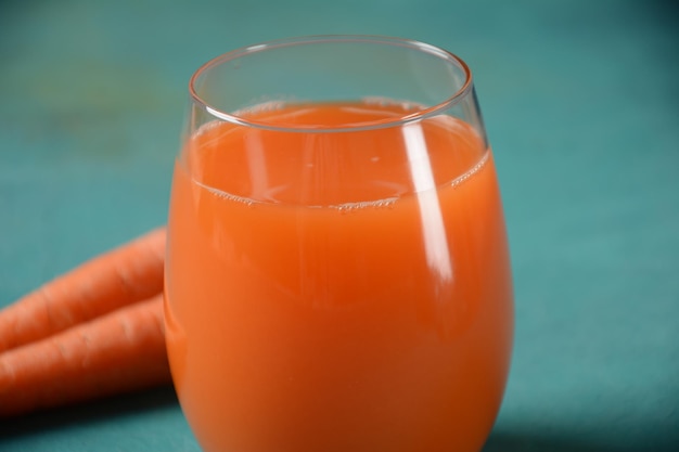 Frisch gepresster Karottensaft in einem Glas mit Karotten auf einem Tisch Gesunde Ernährung Detox Diät und vegetarisches Konzept