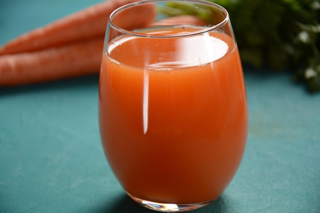 Frisch gepresster Karottensaft in einem Glas mit Karotten auf einem Tisch Gesunde Ernährung Detox Diät und vegetarisches Konzept