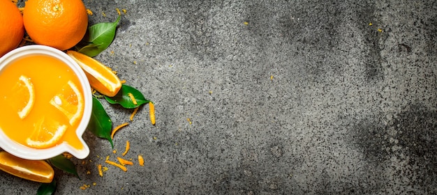 Frisch gepresster Orangensaft mit Fruchtstücken auf rustikalem Hintergrund