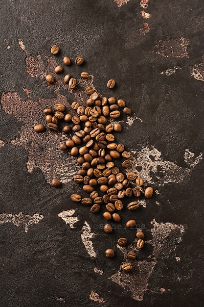 Frisch geröstete Vollkornprodukte von Arabica-Kaffee auf einer alten braunen strukturierten Oberfläche