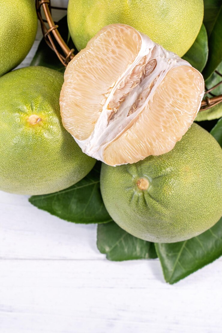 Frisch geschälte Pampelmuse pummelo Grapefruit Shaddock auf hellem Holzhintergrund Herbstsaison Obst Draufsicht flach lag Tischplatte erschossen