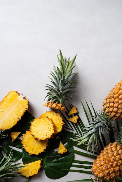 Frisch geschnittene Ananas mit tropischen Blättern auf dunkelblauem Hintergrund