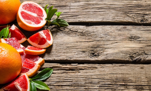 Frisch geschnittene Grapefruit mit Blättern. Auf einem Holztisch. Freier Platz für Text.