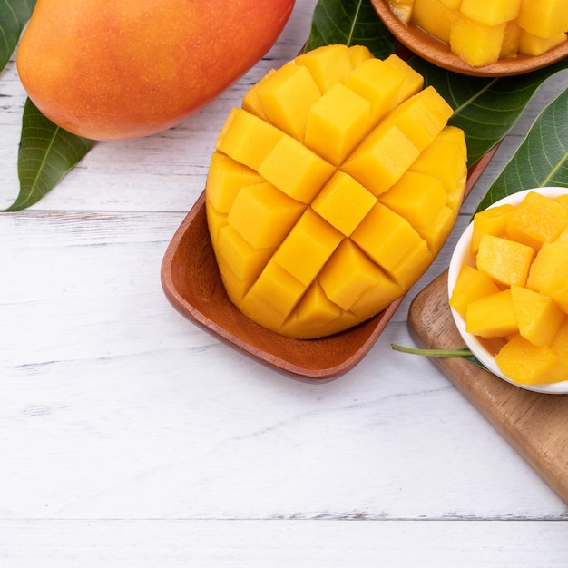 Frisch geschnittene Mango auf einem Tablett und heller rustikaler Holzhintergrund Tropisches Sommerfrucht-Design-Konzept Close-up-Makro-Copy-Raum