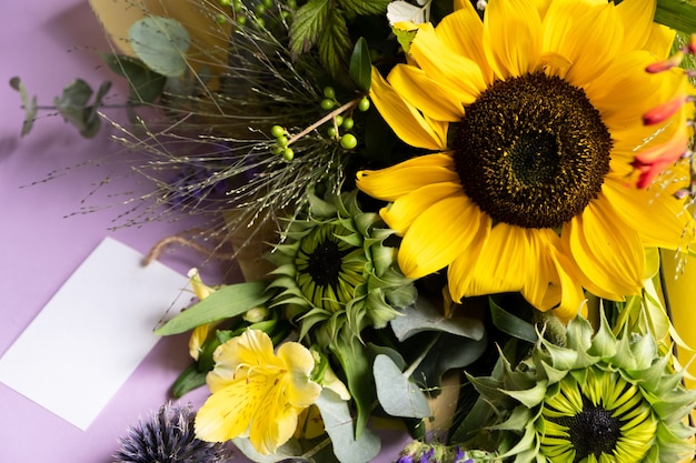 Foto frisch geschnittene sonnenblumen in blumenstrauß und karte mit umschlag mit kopierraum