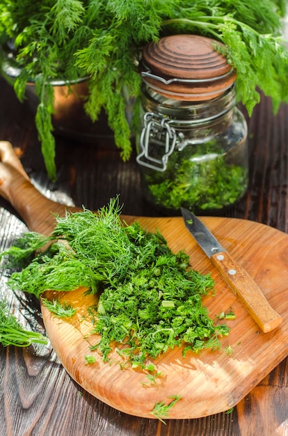 Frisch geschnittener grüner junger Dill, gehackt auf einem Küchenbrett