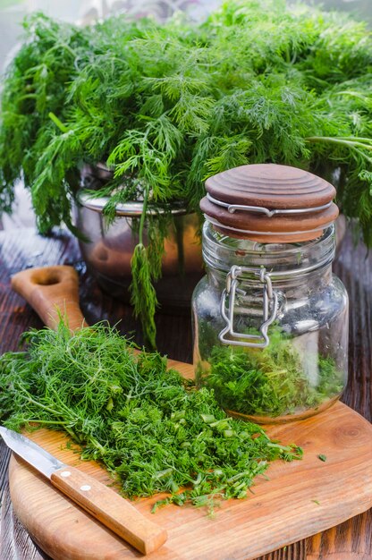 Frisch geschnittener grüner junger Dill, gehackt auf einem Küchenbrett