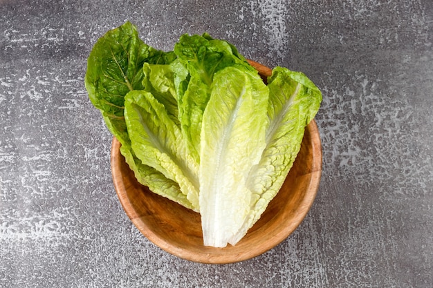 Frisch gewaschener grüner Salat in der Holzschale bereit zum Kochen. Zutaten zum Kochen, vegetarische Ernährung, gesunde Ernährung. Draufsicht, Platz für Text.