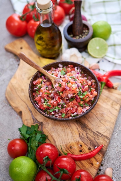 Frisch zubereitete Salsa-Dip-Sauce, gehackte Knoblauchtomaten und Zwiebeln in Holzschüssel