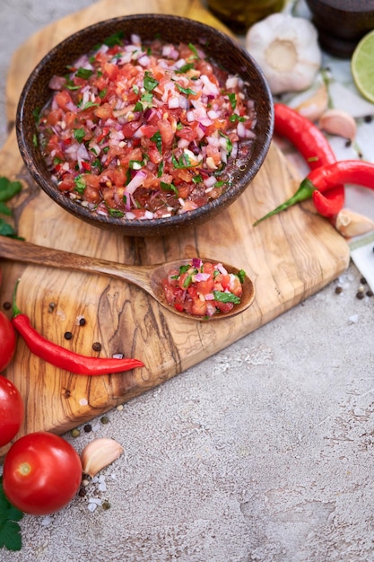 Frisch zubereitete Salsa-Dip-Sauce, gehackte Knoblauchtomaten und Zwiebeln in Holzschüssel