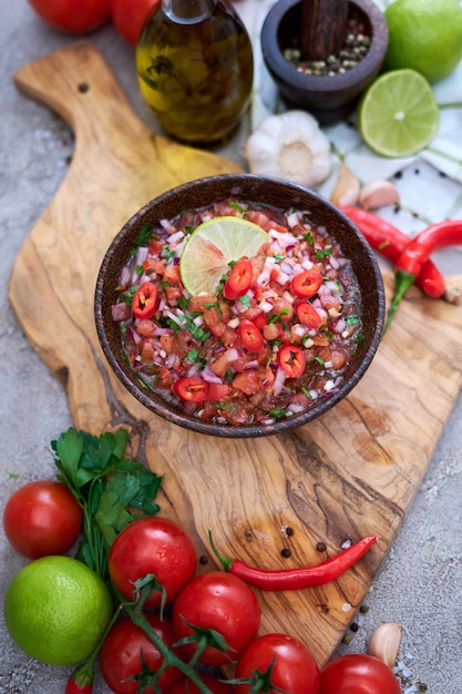 Frisch zubereitete Salsa-Dip-Sauce, gehackte Knoblauchtomaten und Zwiebeln in Holzschüssel