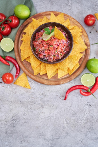 Frisch zubereitete Salsa-Dip-Sauce mit Nacho-Chips auf Holzbrett