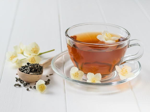 Frisch zubereiteter tee mit jasminblüten auf einem tisch.