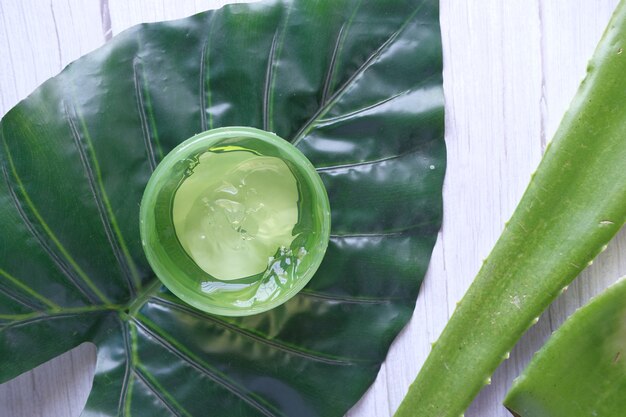 Frische Aloe Vera in Scheiben geschnitten und flüssiges Gel in Plastikbehälter auf Weiß