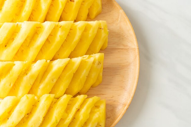 frische Ananas auf Holzteller geschnitten