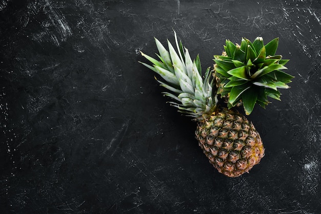 Frische Ananas auf schwarzem Steinhintergrund Draufsicht Freier Kopierplatz