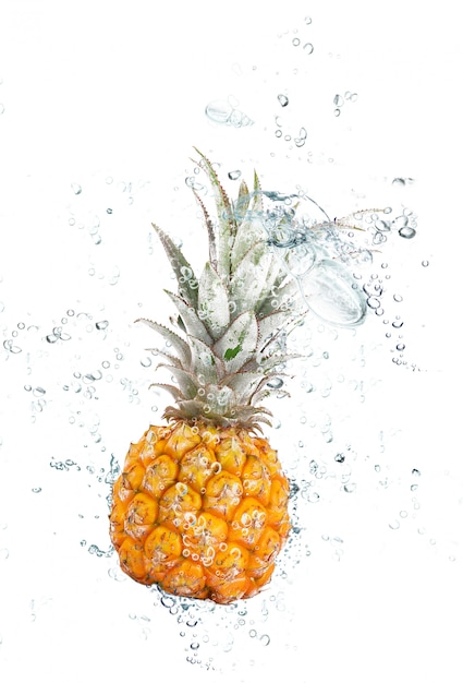 Frische Ananas, die in Wasser fällt