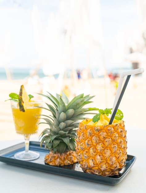 frische Ananas-Smoothies mit Meeresstrand-Hintergrund