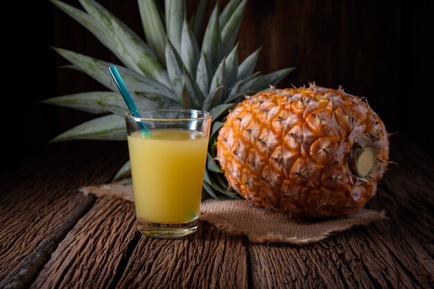 Frische Ananas und Saft auf Holztisch.