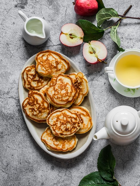 Frische Apfelcreme des köstlichen Frühstücksapfelpfannkuchen-grünen Tees auf einer Draufsicht des grauen Hintergrundes